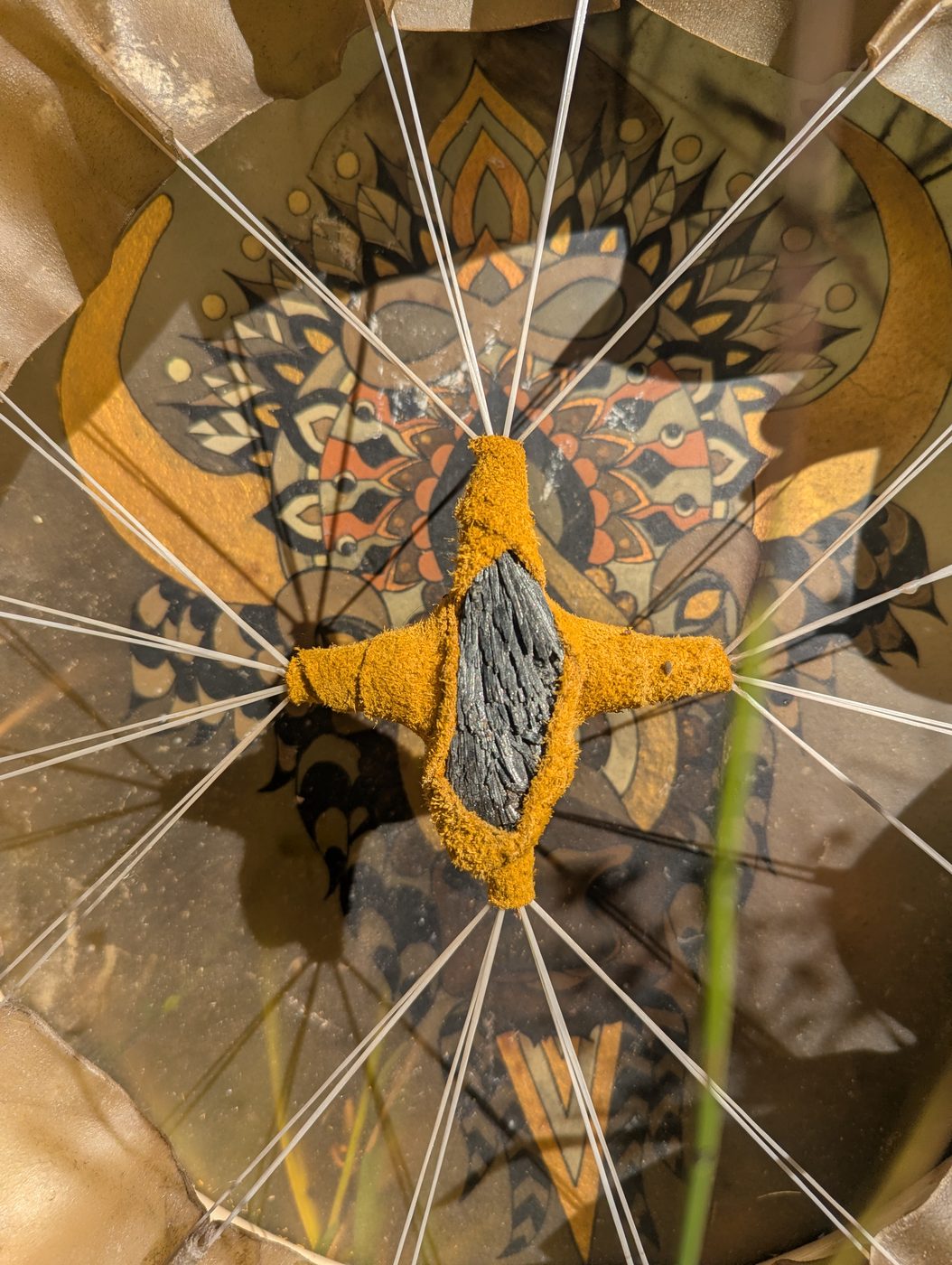 Back of the bison drum, with a crystal wrapped in golden leather at the centre of the lacing